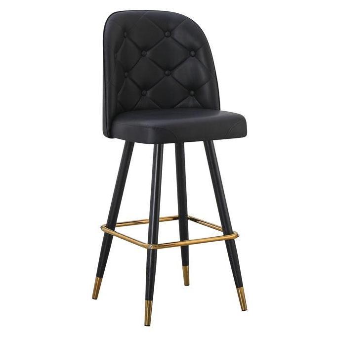 Swivel metal bar stool with black tufted seat and gold footrest