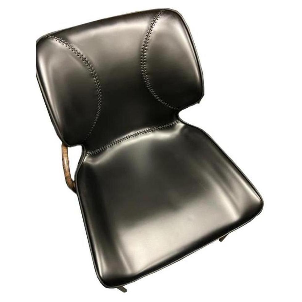 Chaise interior de metal con acabado en madera y asiento de vinilo negro.
